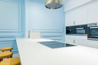 Bright kitchen with a white quartz countertop and cooktop