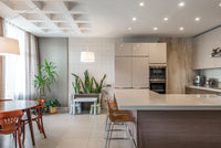 Open kitchen with a light stone island and dining area