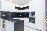 Modern white kitchen with dark stone countertops